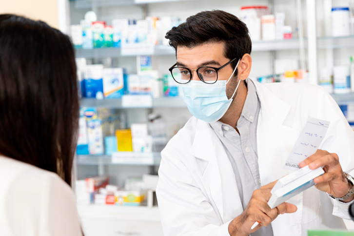 Farmacia Habana 52 La imagen muestra un farmacéutico mostrando un medicamento a una clienta